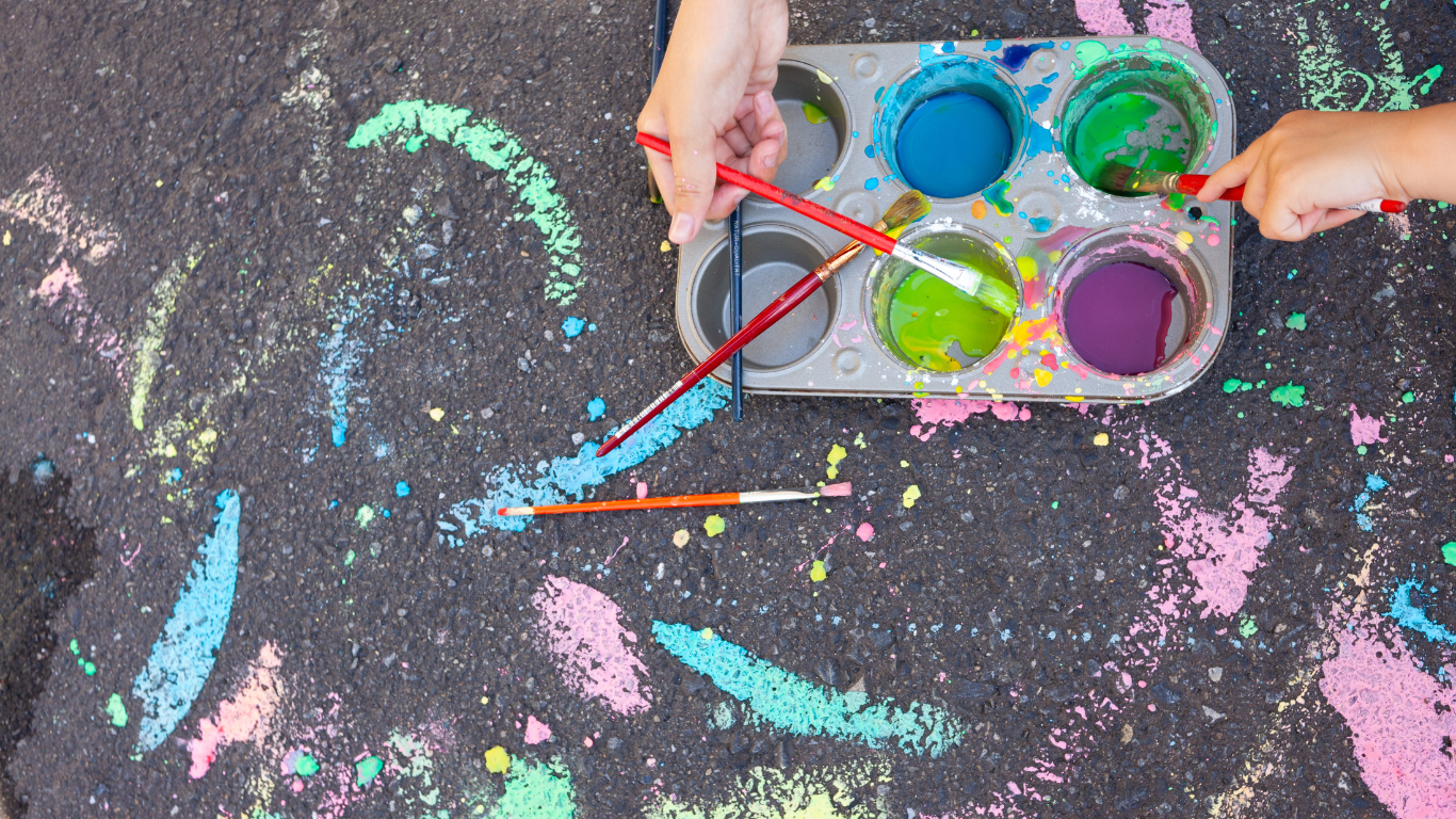 muffin tin paint pallet with chalk paintings on pavement