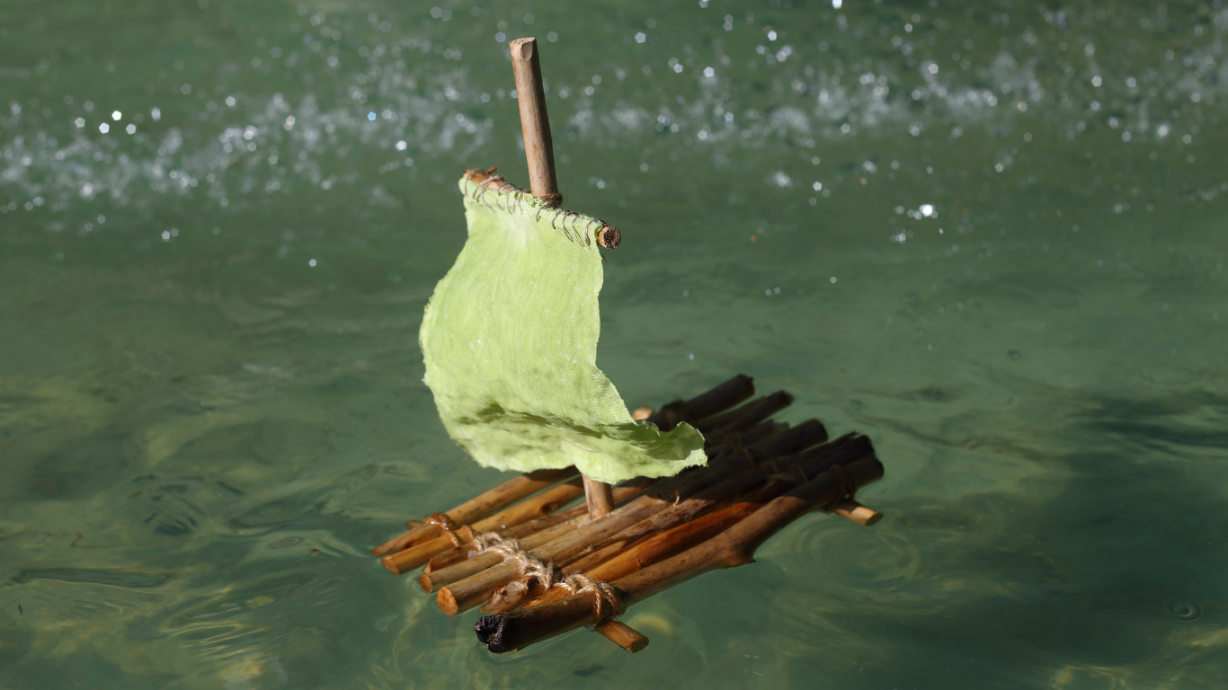 homemade raft made from sticks floating in water