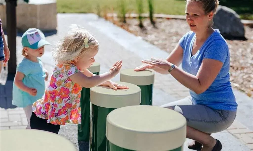 Mother and daughter playing with drums in park - Freenotes Harmony Park