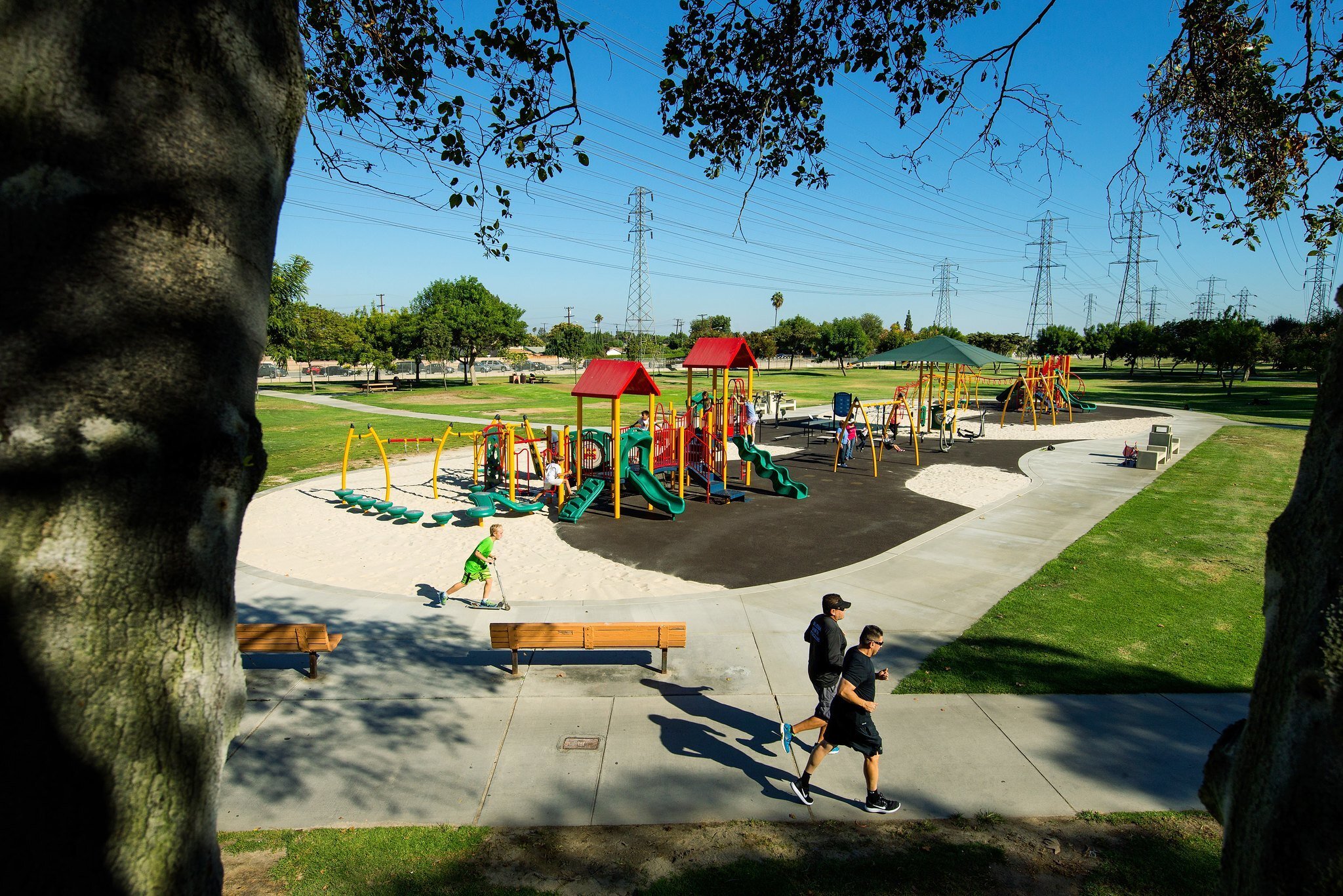 IMPACT Parks project - runners on trail surrounding playground