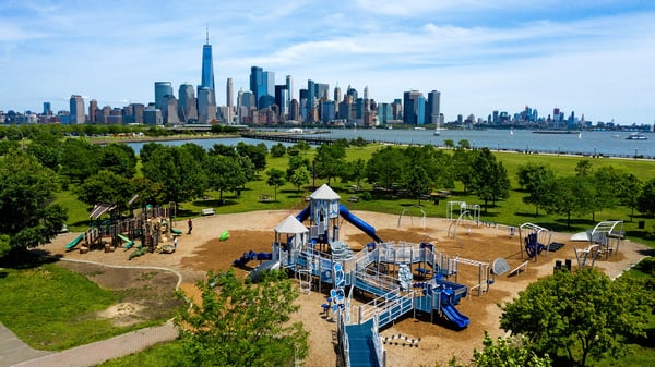 IMPACT Parks playground in park surrounded by big city
