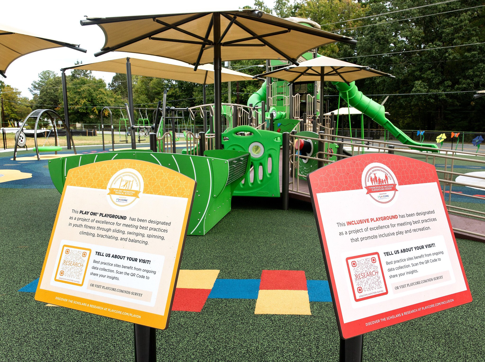 Signs at park with QR codes to scan and review your experience.