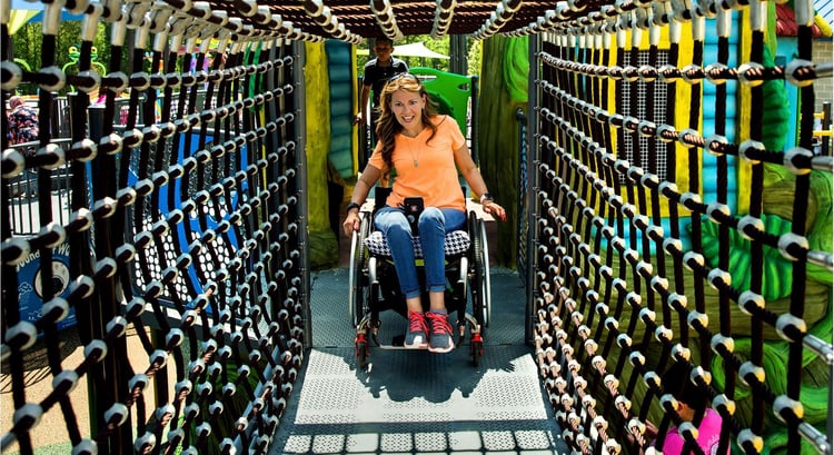 A woman enjoying a wheelchair accessible play structure by Hoover parks and recreation