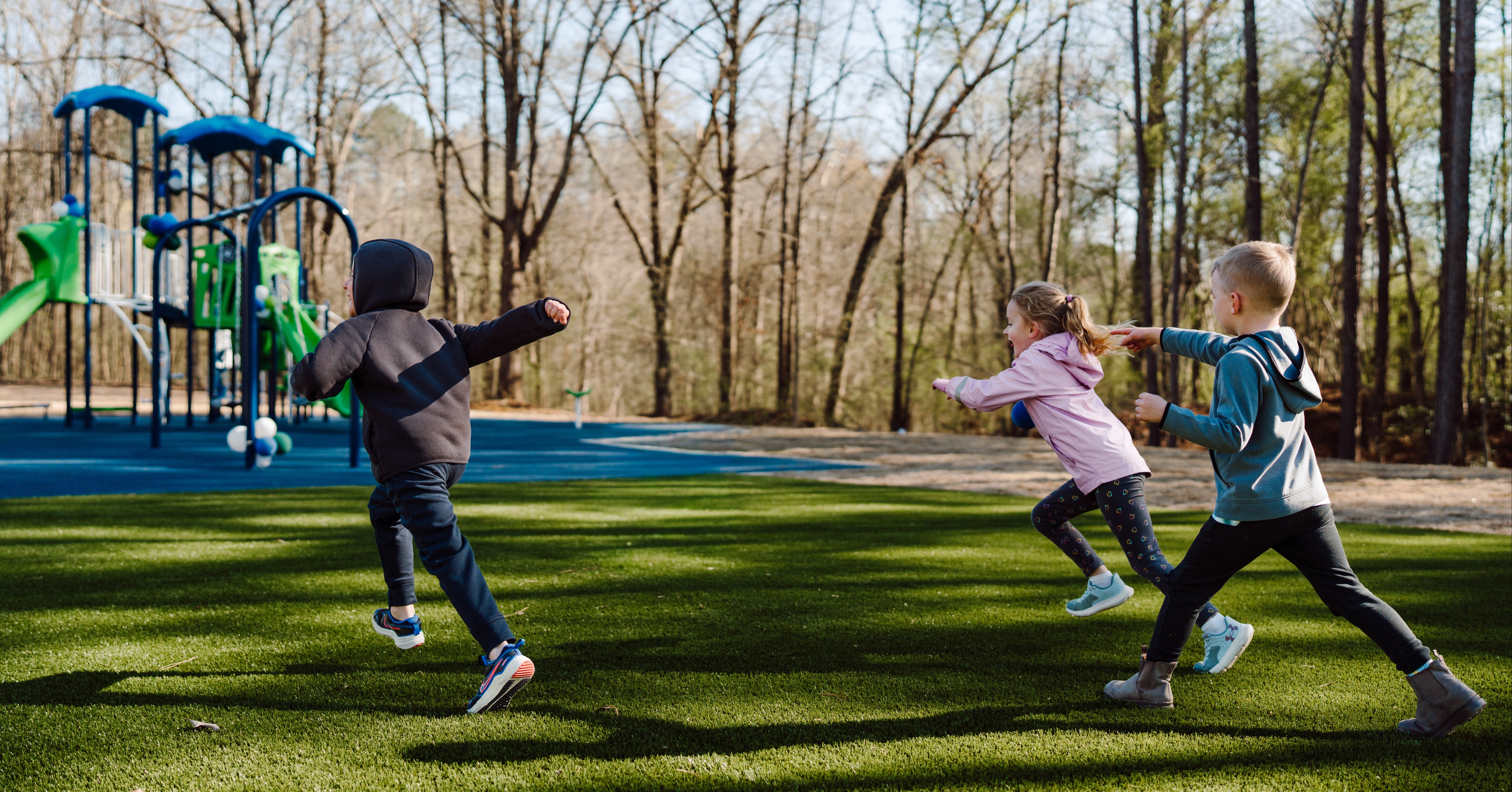 Group of kids running towards Impact Parks playground