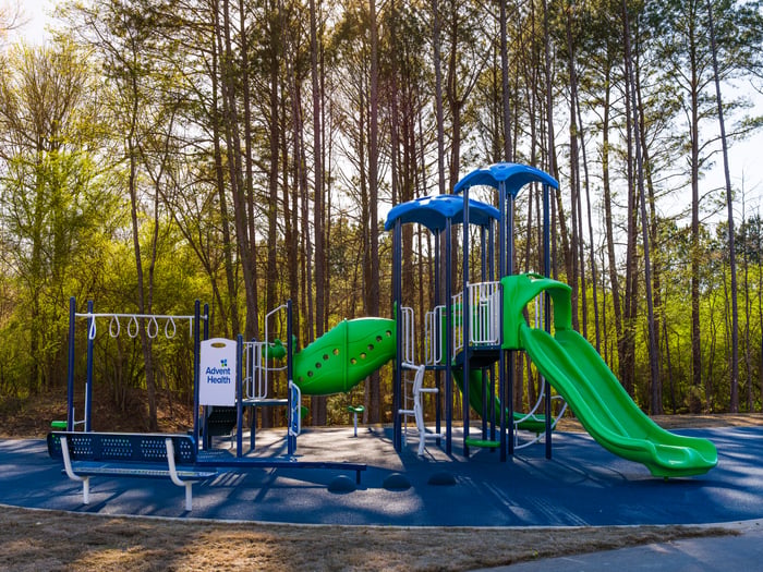 a blue and green playground in the forest 