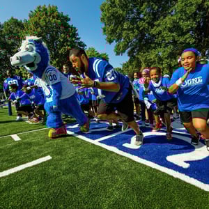 Indianapolis Colts Grand Opening- players and kids raising to the playground with the Colts mascot Indianapolis Colts Grand Opening- players and kids raising to the playground with the Colts mascot