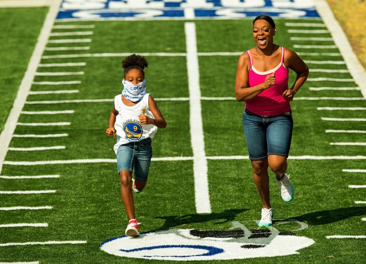 A mother and daughter racing on the football themed track