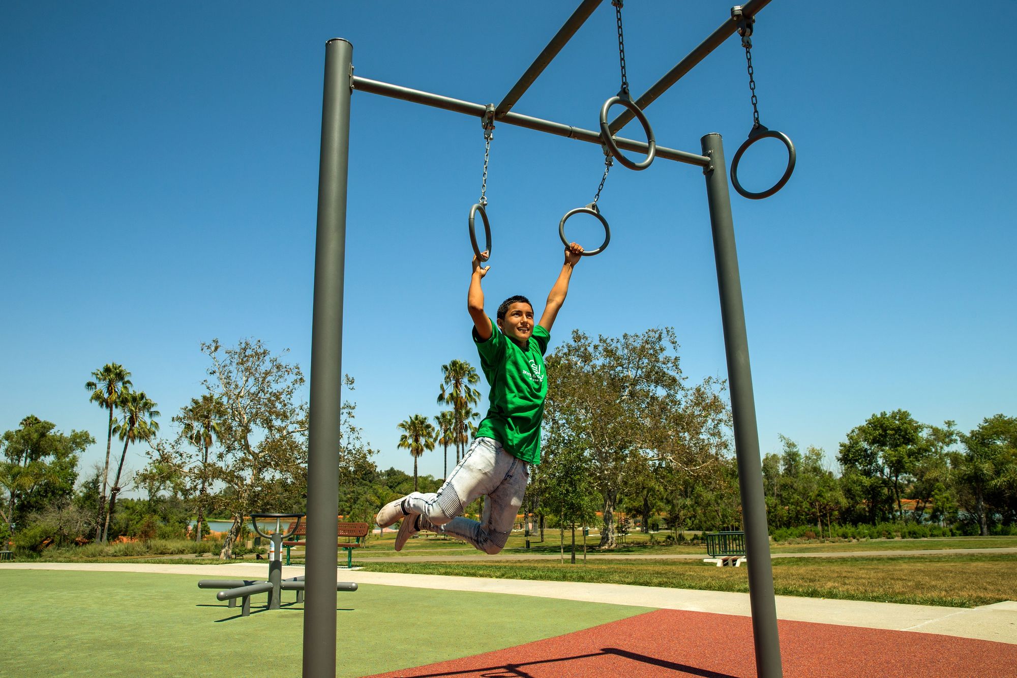 Boy swinging on rings at Keiser Permanente Park 