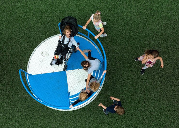 Children playing on accessible merry-go-round