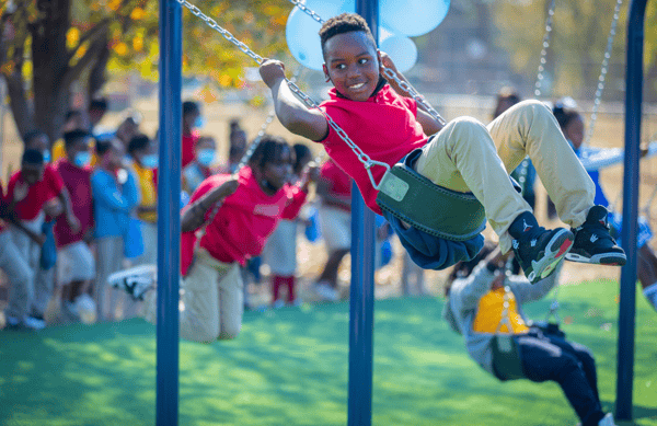 Child on swing at BCBS and IMPACT Parks playground