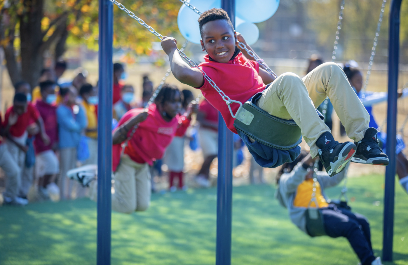 Child swinging on BCBS playground by IMPACT Parks