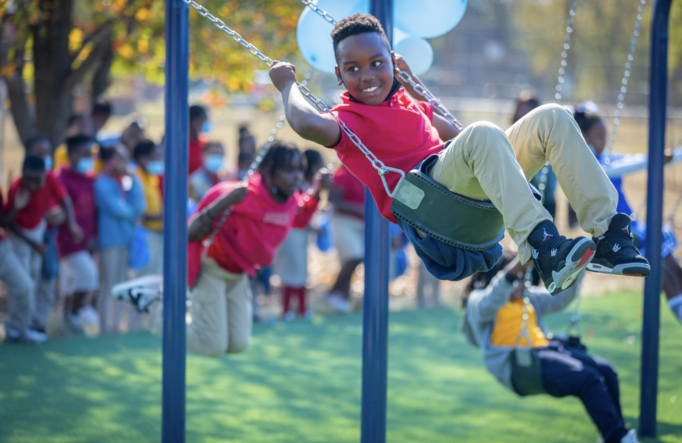 Child on swing at BCBS and IMPACT Parks playground