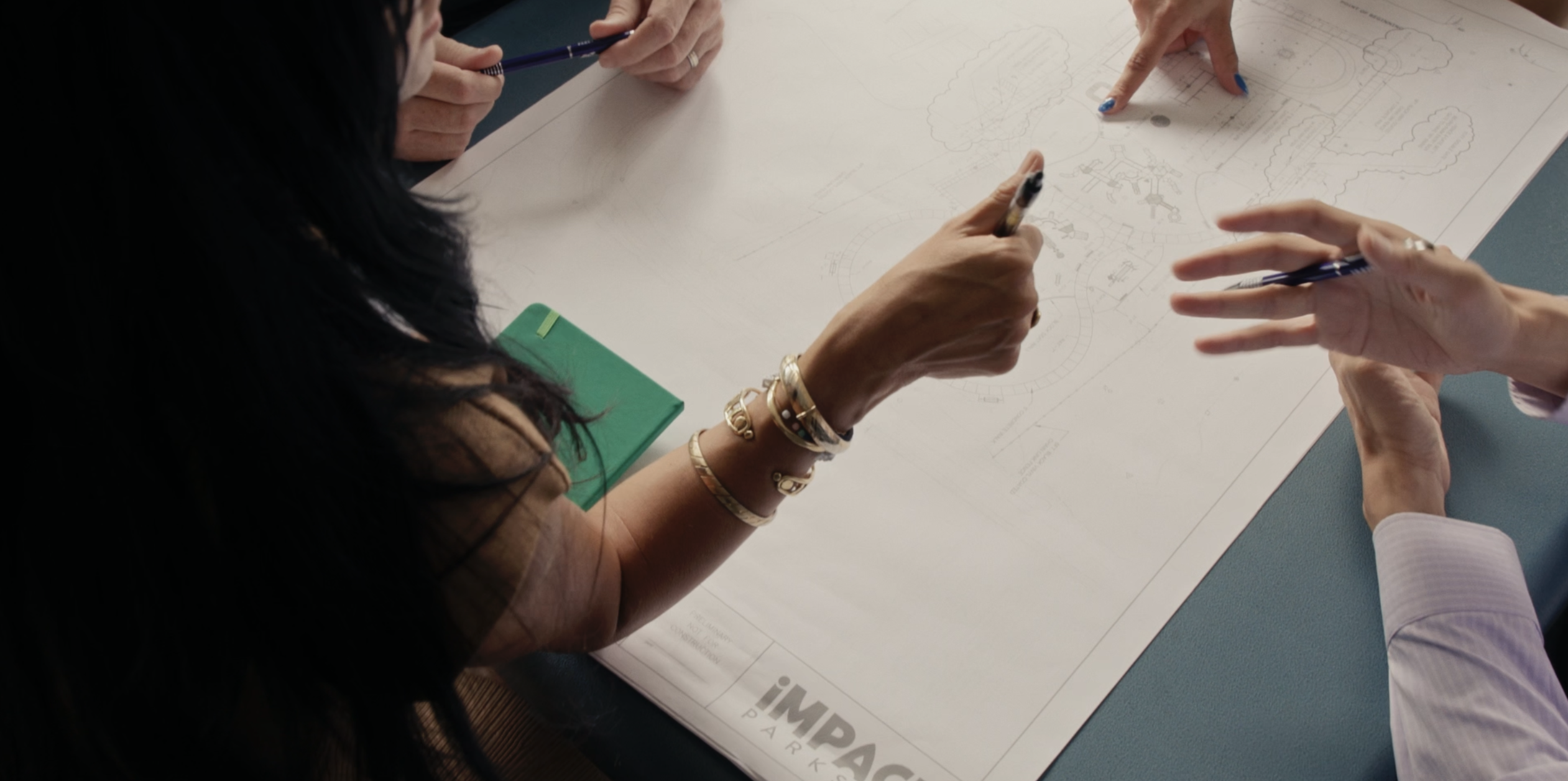 IMPACT Parks design team sat around table with playground plans