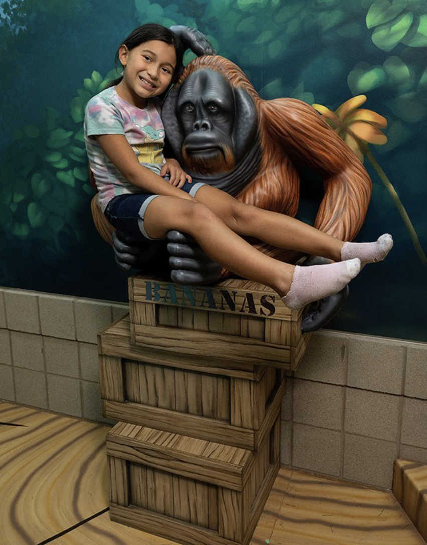 Girl hugging monkey statue in West Chicago Park District