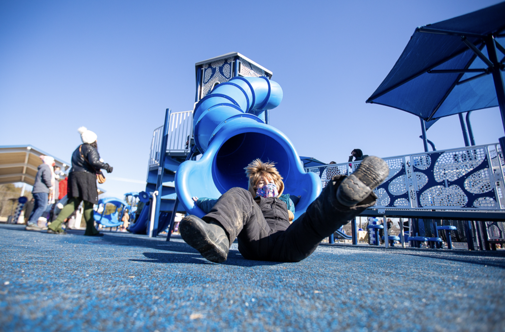 Kid going down slide at YMCA outdoor park