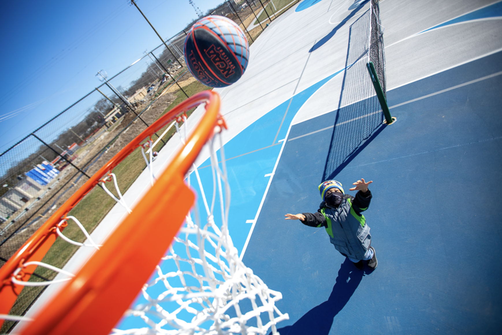 Kid shooting basketball at outdoor court at YMCA