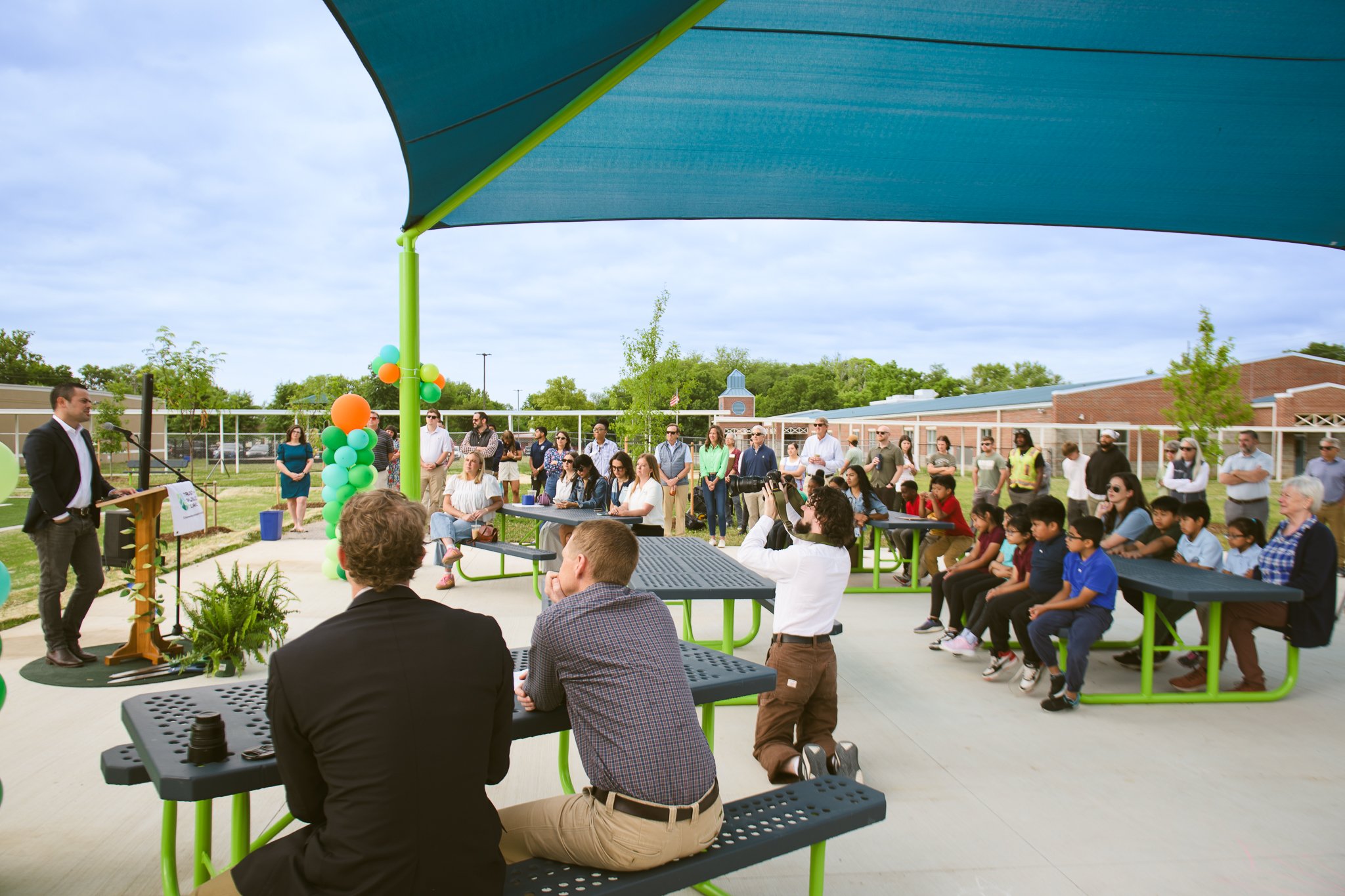 TN Community Schoolyard Ribbon-Cutting - community gathered under shaded picnic area