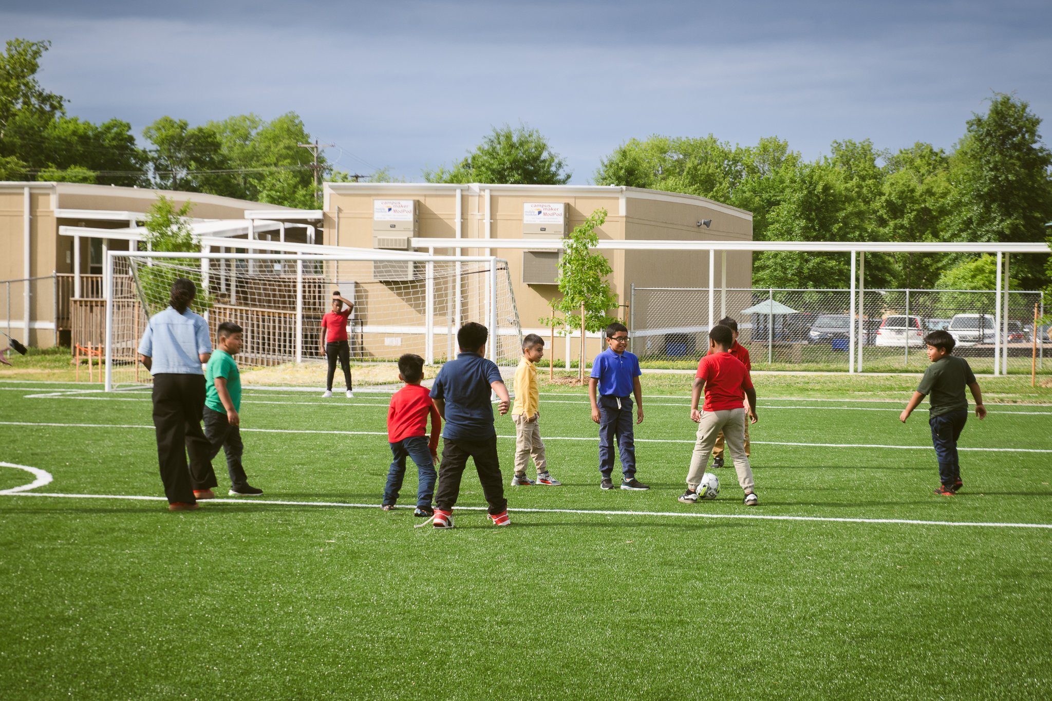 TN Community Schoolyard Ribbon-Cutting- group of local students playing soccer on new field