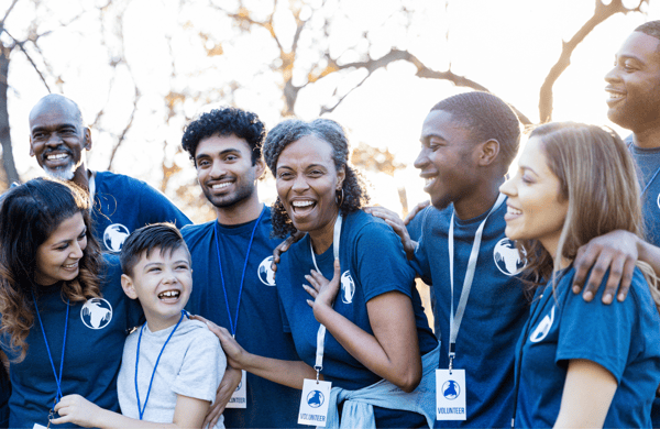 Group of employees in volunteer shirts outdoors