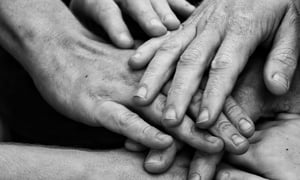 a black and white photo of hands placed togther