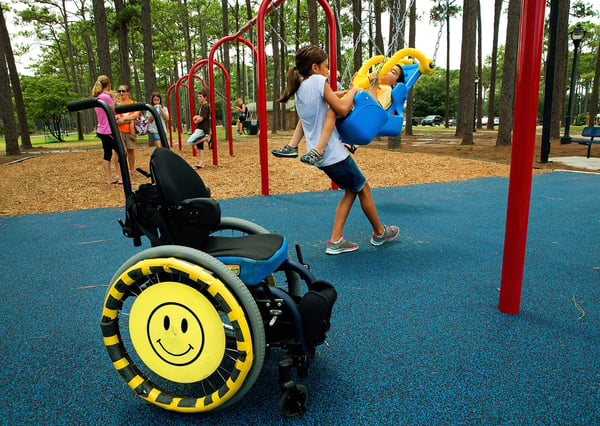Children playing on IMPACT Parks swing set