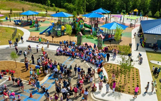 crowd surrounding a ribbon cutting at the EXPLORE park